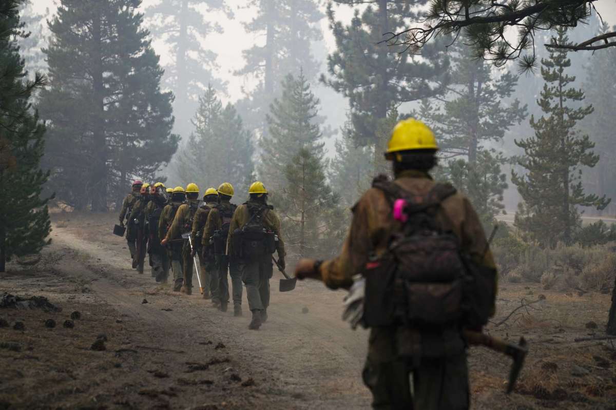 A hotshot crew from Tahoe Hotshots hikes along a trail in Meyers, Calif., Friday, Sept. 3, 2021. Fire crews took advantage of decreasing winds to battle a California wildfire near popular Lake Tahoe and were even able to allow some people back to their homes but dry weather and a weekend warming trend meant the battle was far from over.