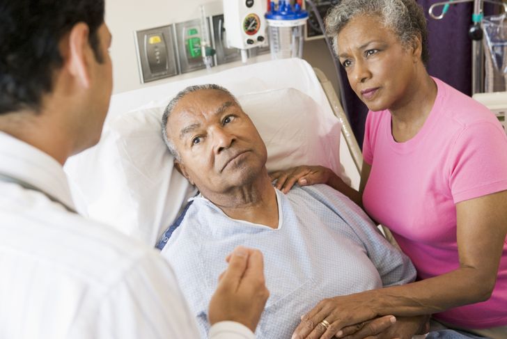 doctor talking to elderly couple in hospital
