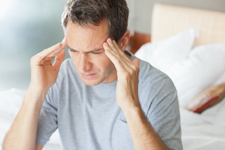 Man with headache rubbing forehead