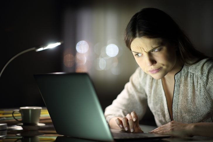 cynical woman reading information on internet
