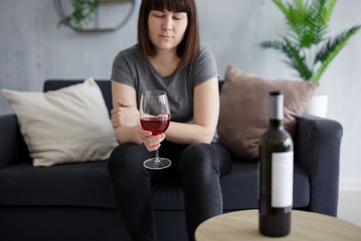 woman home alone with wine bottle
