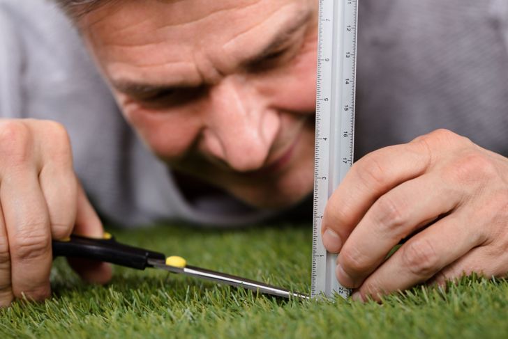 man with obsessive disorder measuring grass