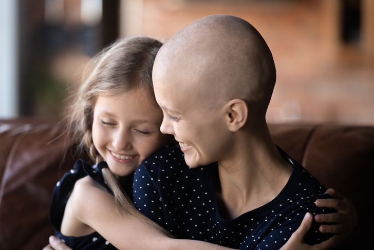 smiling mother with cancer hugging daughter