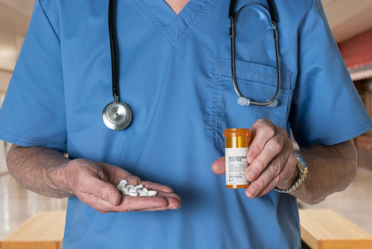 doctor holding a handful of prescription pills