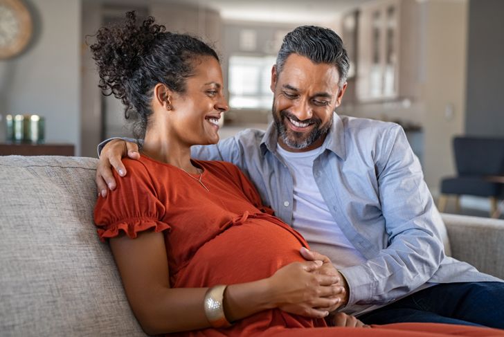 smiling pregnant woman and her partner