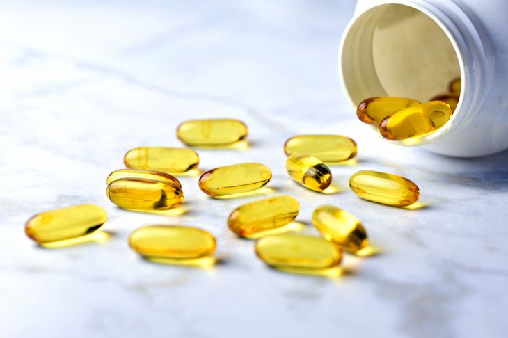 Bottle of yellow fish oil pills on the table