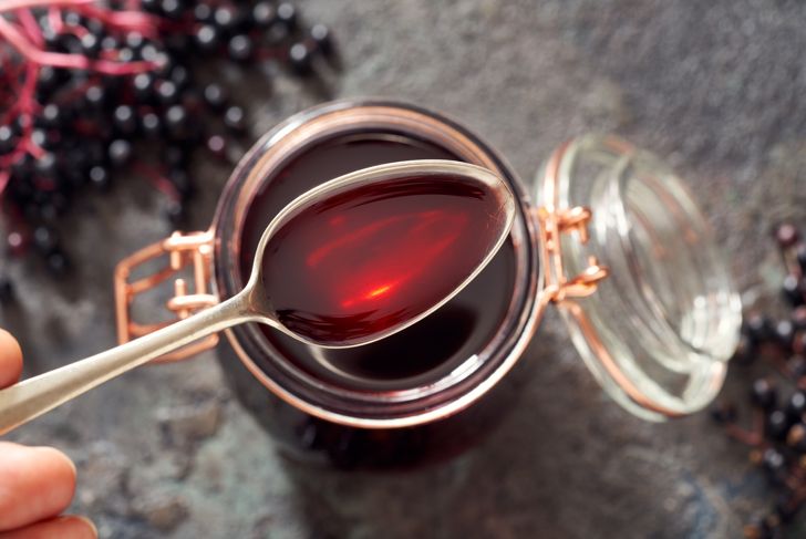 Spoon with homemade elderberry syrup