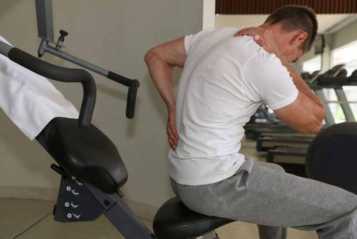 man experiencing back pain after exercise