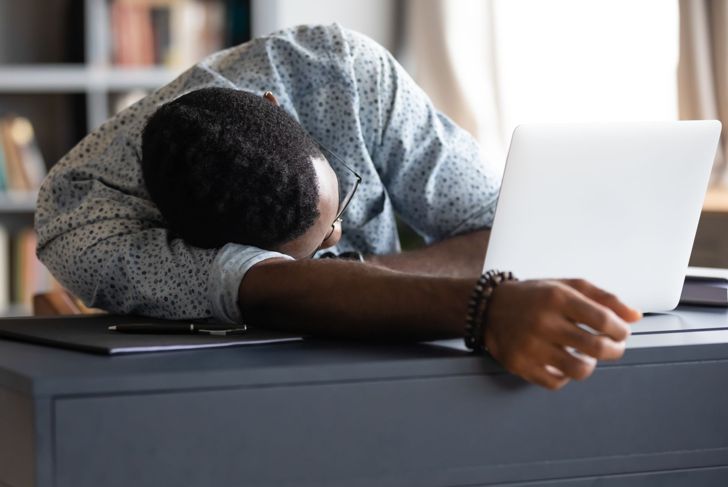 exhausted man falling asleep at his desk