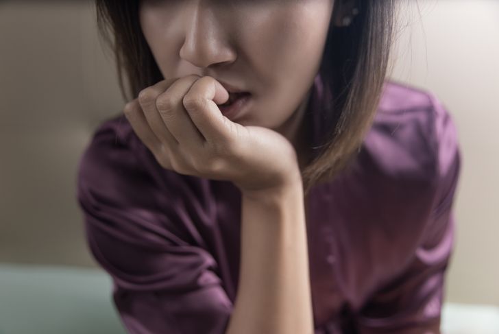 close up shot of anxious woman chewing her nails