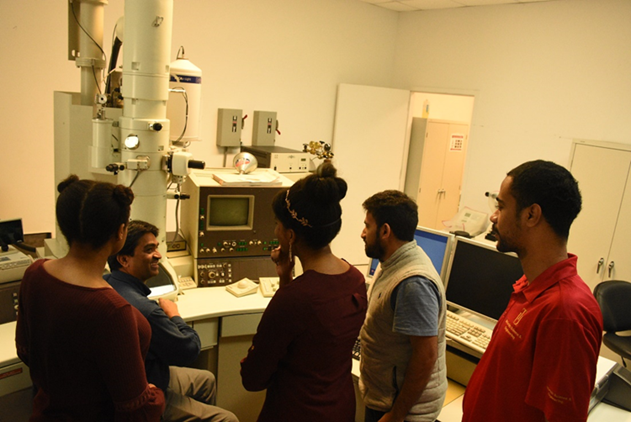 students standing in a huddle learning about electron microscopy