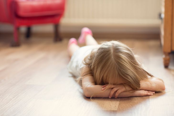 girl lying on the floor with head in hands