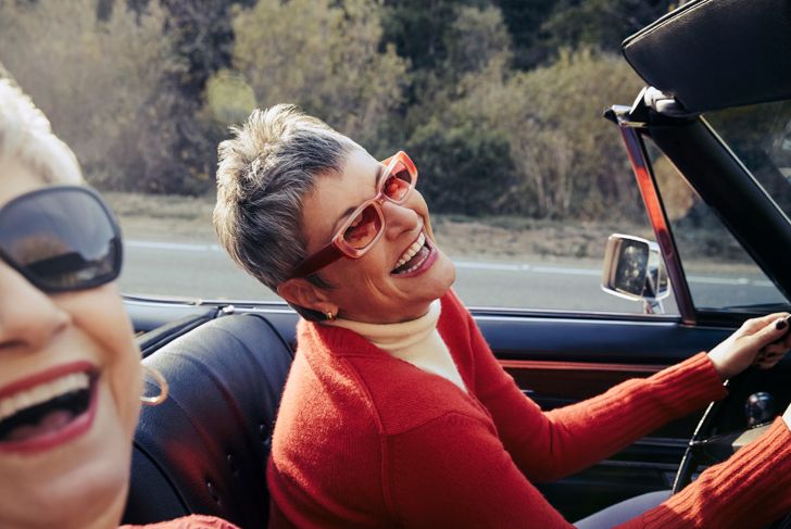 two senior woman laughing in the car