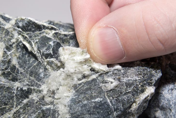 Asbestos mineral fibers in human fingers, close up.
