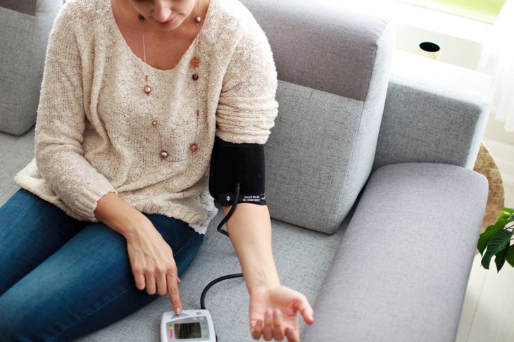 Woman measuring her blood pressure at home