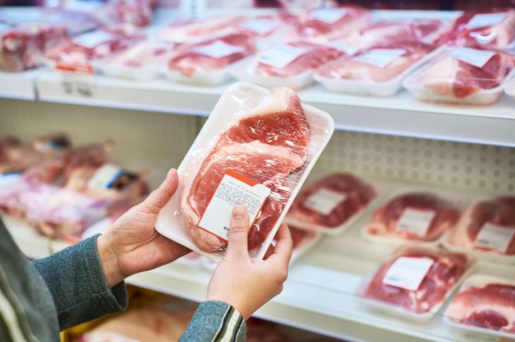 Buyer hands with pork at grocery store 