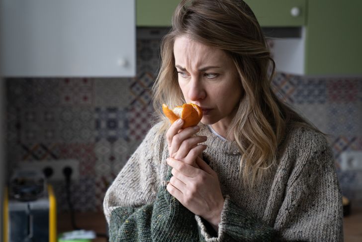 Woman tries to feel the smell of mandarin orange