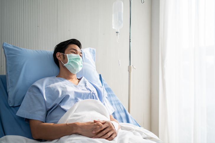 patient lying in the hospital bed and wearing a mask