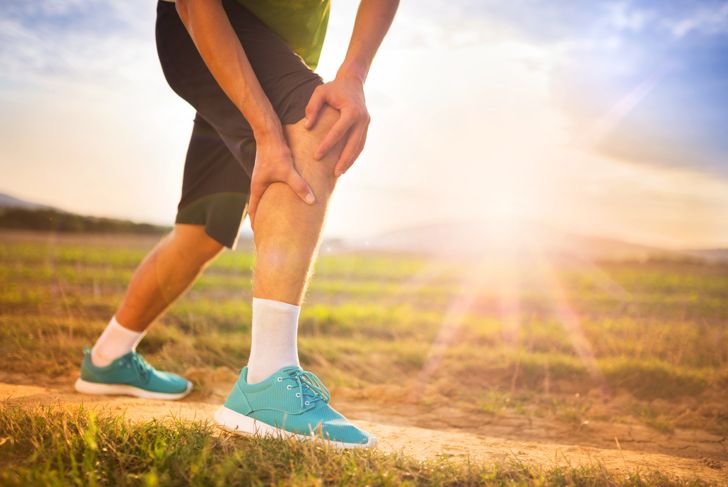 Runner leg and muscle pain during running training outside in summer nature