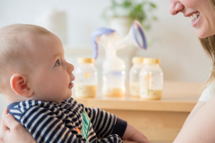 woman with little son near breast milk bottles