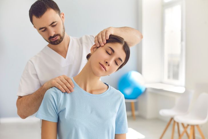 therapist doing stretching exercises on the patient's neck