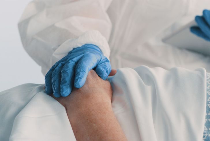 shot of doctor holding patient's hand