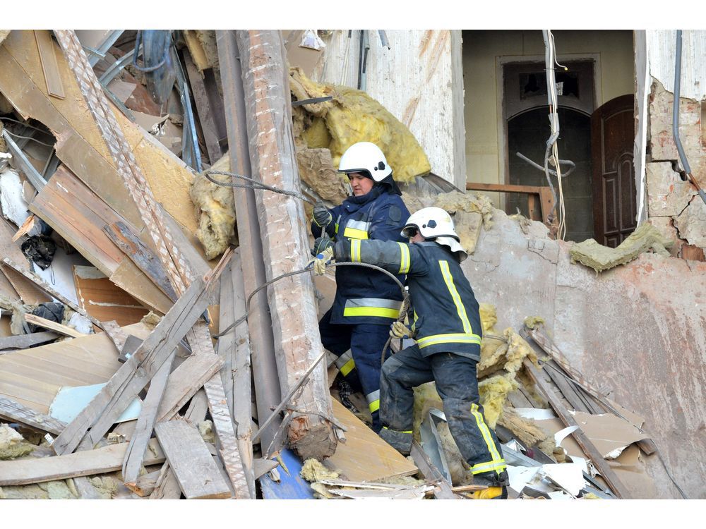 Rescuers remove debris from a building damaged by shelling in central Kharkiv on March 16.