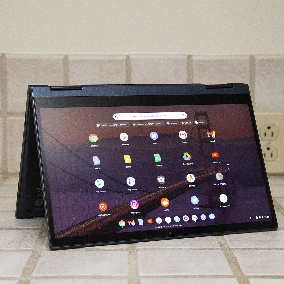 The ThinkPad C13 Yoga Chromebook in tent mode.  The screen shows a grid of Android apps.