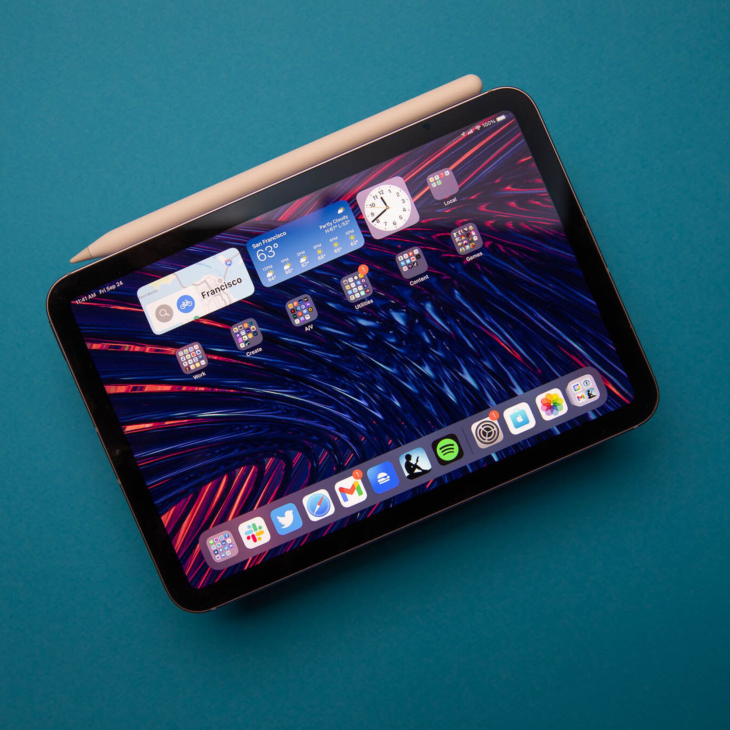 Photo of the 2021 ipad mini with the second-generation apple pencil attached on a blue background